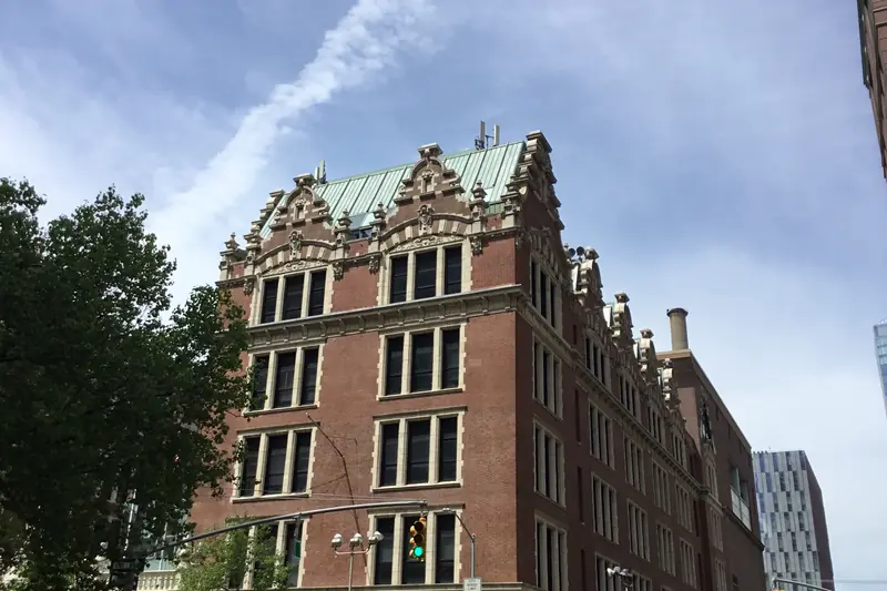 Haaren Hall of John Jay College of Criminal Justice in Manhattan, a brick building with ornate stone gables and a green roof.