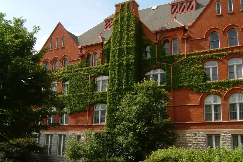 Old Main at Macalester College in Saint Paul, its red-brick walls covered in ivy.