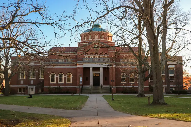 Alumni Hall at Miami University in Oxford, Ohio, a red-brick building with a green dome, seen through bare trees.