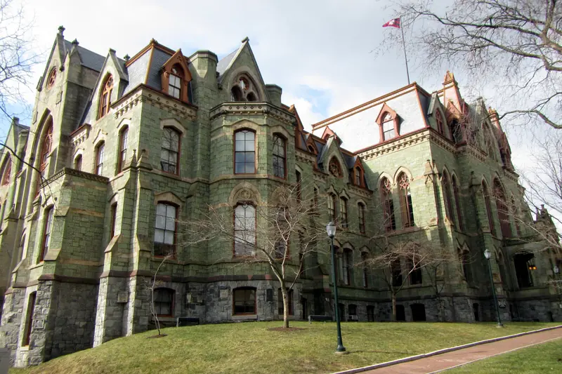 College Hall at the University of Pennsylvania in Philadelphia, sunlit, with the Penn flag.